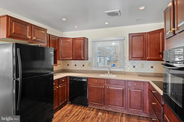 kitchen featuring tasteful backsplash, sink, dark hardwood / wood-style flooring, and black appliances