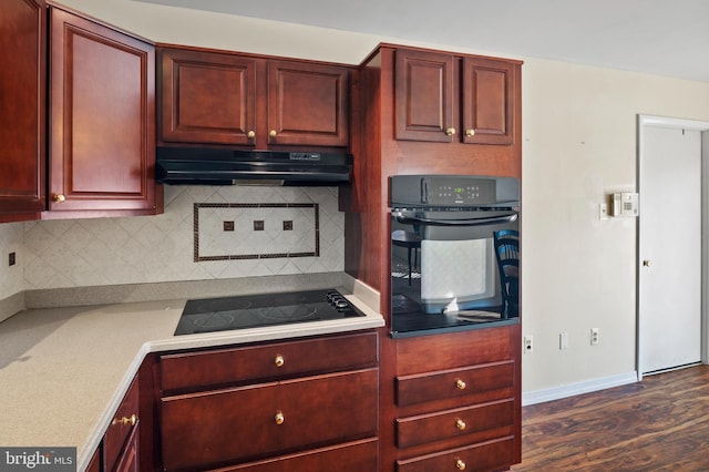 kitchen featuring dark hardwood / wood-style floors, decorative backsplash, and black appliances