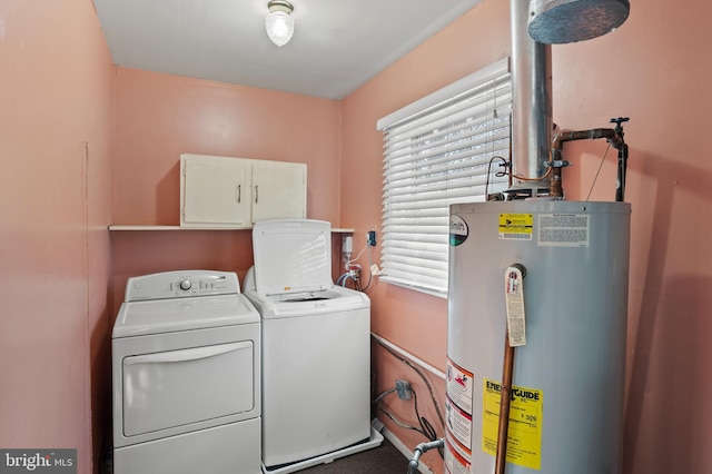 washroom featuring water heater, washer and dryer, and cabinets