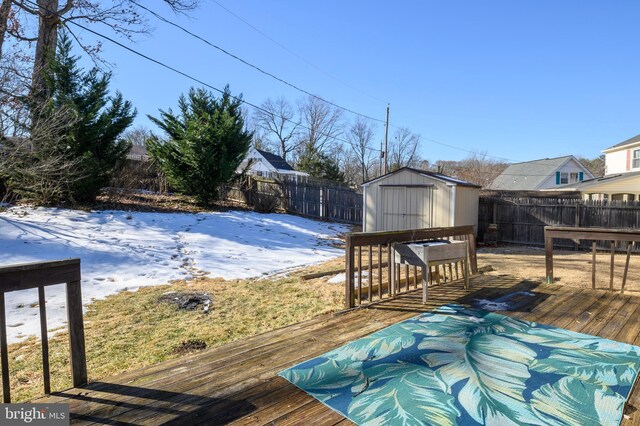 snow covered deck featuring a storage unit