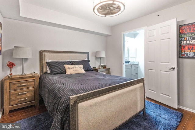 bedroom featuring connected bathroom and dark hardwood / wood-style floors