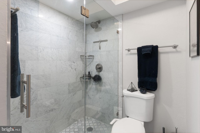 bathroom featuring toilet and a shower with door