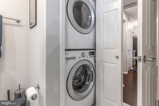 washroom featuring stacked washer / drying machine and wood-type flooring