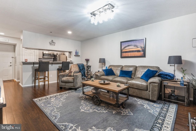 living room with dark hardwood / wood-style floors and a textured ceiling