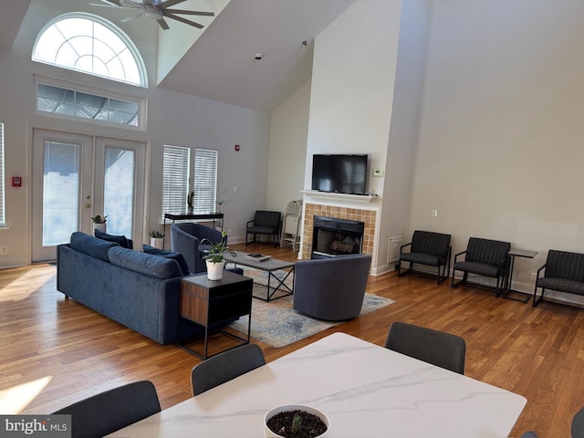 living room featuring a tiled fireplace, hardwood / wood-style floors, plenty of natural light, and french doors