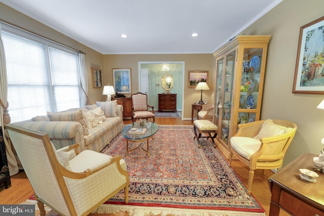 sitting room featuring crown molding and light hardwood / wood-style flooring