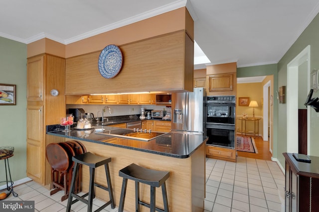 kitchen with a kitchen bar, kitchen peninsula, light tile patterned floors, and black appliances