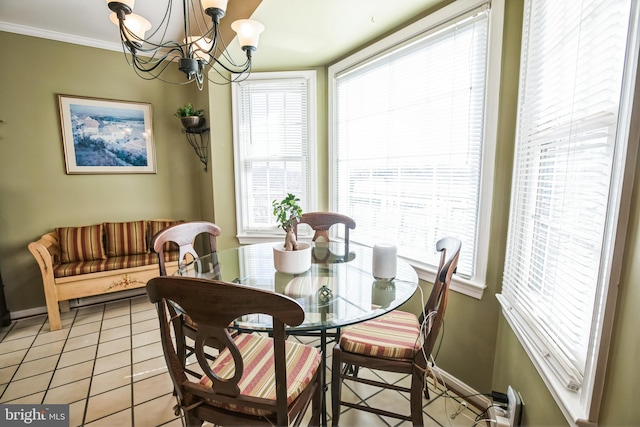 dining area featuring a notable chandelier, crown molding, and light tile patterned floors