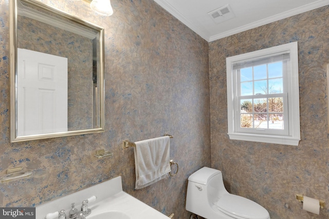 bathroom with ornamental molding, toilet, and sink