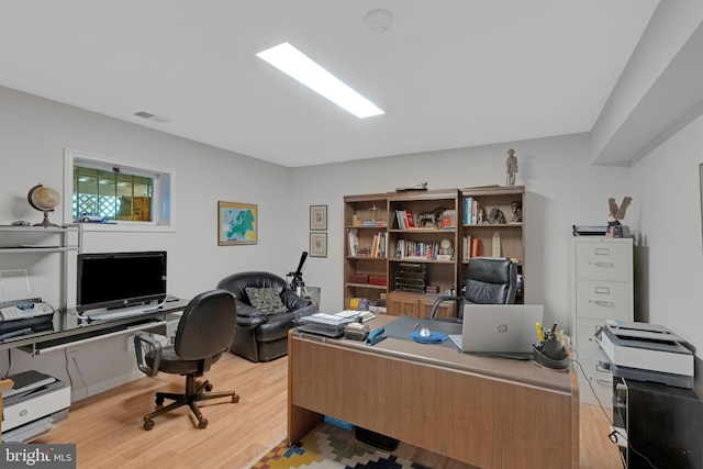 home office with light hardwood / wood-style floors