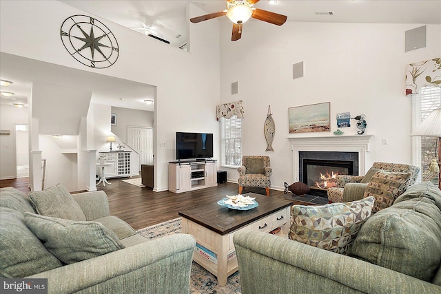 living room featuring ceiling fan, dark hardwood / wood-style flooring, and a high ceiling