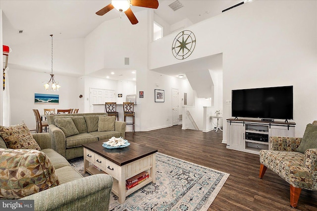 living room featuring lofted ceiling, dark hardwood / wood-style flooring, and ceiling fan with notable chandelier