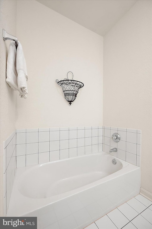 bathroom with a bath and tile patterned flooring