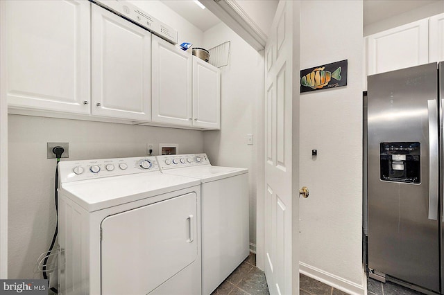 clothes washing area featuring cabinets and separate washer and dryer