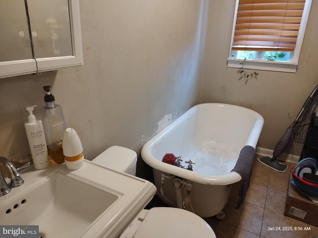 bathroom featuring a bath, tile patterned flooring, and sink