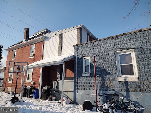 view of snow covered back of property