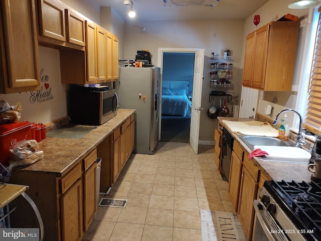 kitchen with sink, light tile patterned floors, and appliances with stainless steel finishes