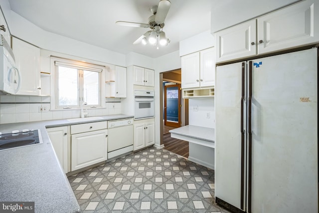 kitchen with white appliances, white cabinets, and light countertops