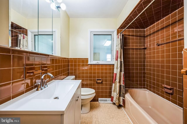 full bathroom featuring tile patterned flooring, toilet, vanity, tile walls, and shower / tub combo with curtain