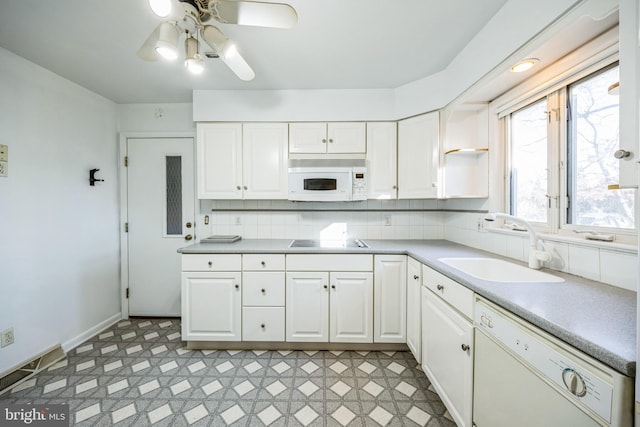 kitchen featuring white appliances, tasteful backsplash, white cabinets, light countertops, and a sink