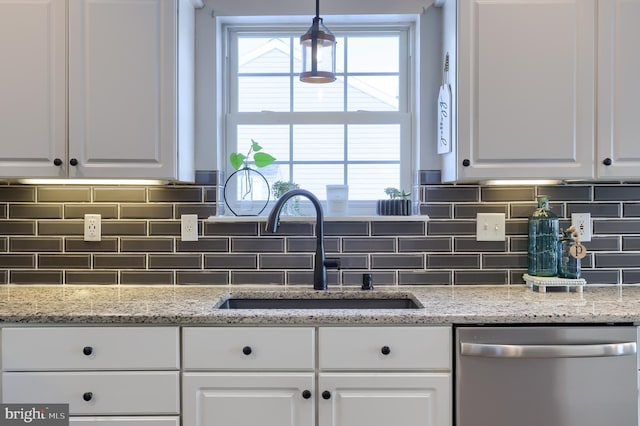 kitchen with hanging light fixtures, stainless steel dishwasher, and white cabinets