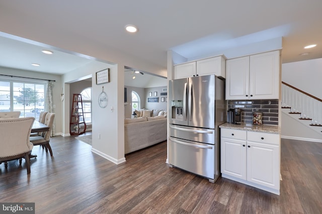 kitchen featuring white cabinetry, stainless steel fridge, light stone counters, and decorative backsplash