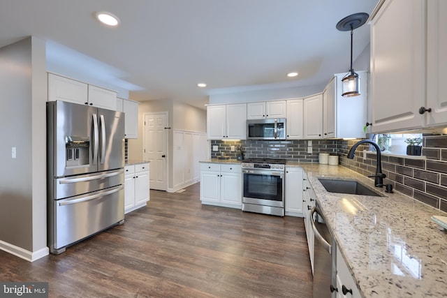 kitchen featuring pendant lighting, white cabinetry, and appliances with stainless steel finishes