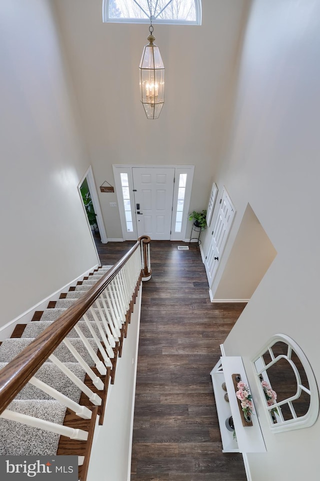 entrance foyer featuring a high ceiling, dark hardwood / wood-style flooring, and a chandelier