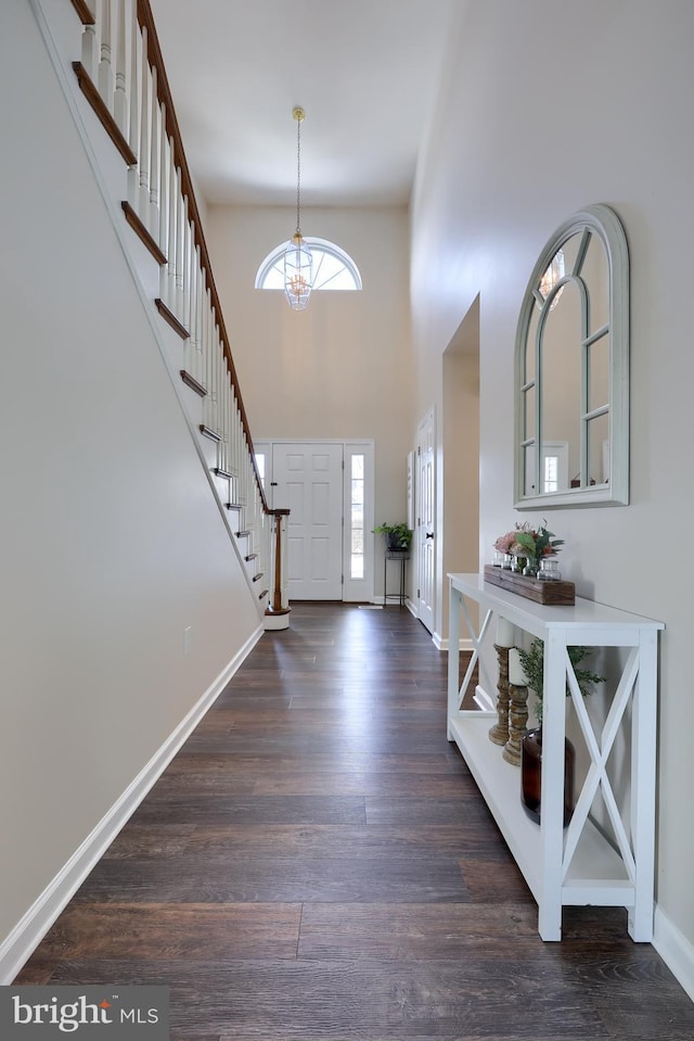 foyer with a high ceiling, a chandelier, and dark hardwood / wood-style flooring