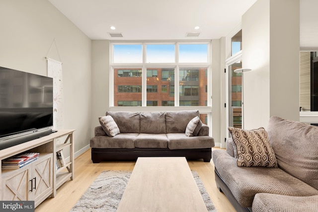 living room featuring floor to ceiling windows and light hardwood / wood-style flooring