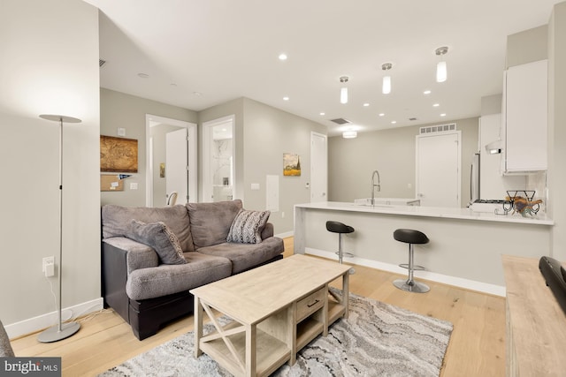 living room with sink and light hardwood / wood-style flooring