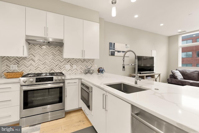 kitchen featuring light stone countertops, appliances with stainless steel finishes, sink, and white cabinets