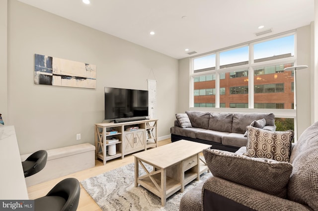 living room featuring hardwood / wood-style flooring and a wall of windows