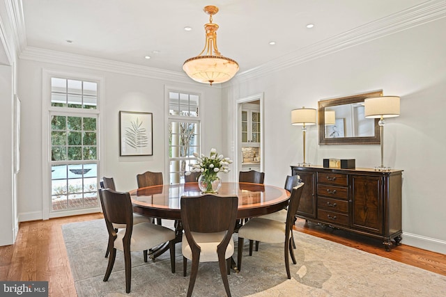 dining area with wood-type flooring, plenty of natural light, and ornamental molding