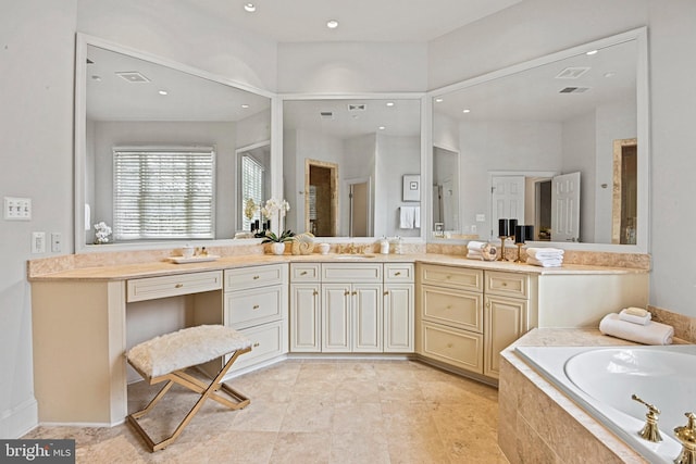 bathroom with vanity and a relaxing tiled tub