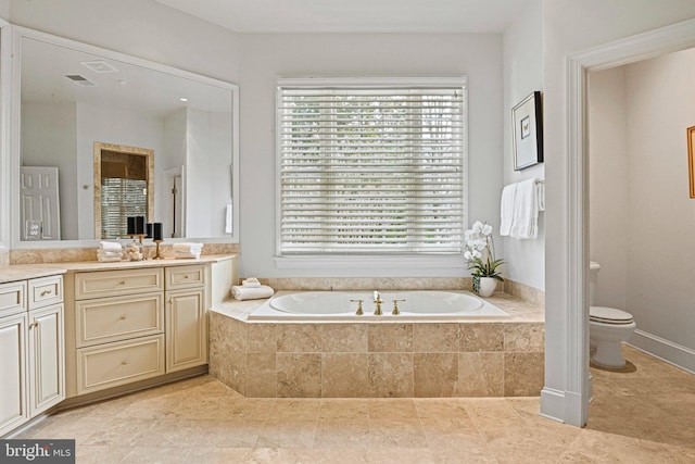 bathroom featuring a relaxing tiled tub, vanity, and toilet