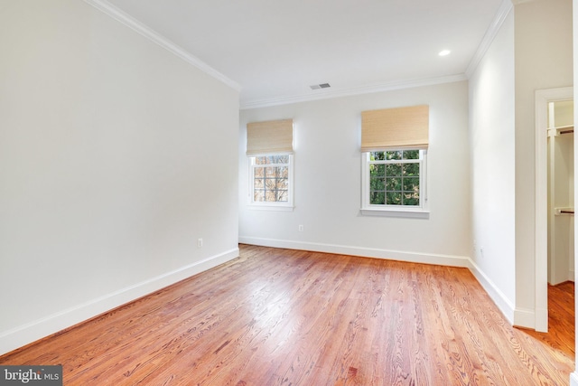 spare room featuring ornamental molding and light wood-type flooring