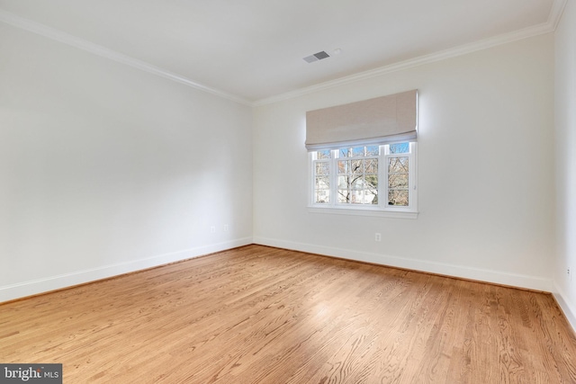 empty room with crown molding and light wood-type flooring