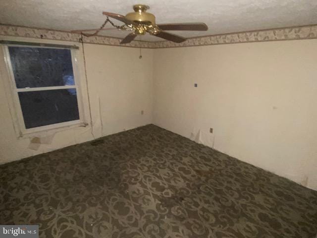 spare room with ceiling fan and a textured ceiling