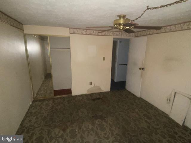 unfurnished bedroom featuring a textured ceiling, a closet, and ceiling fan