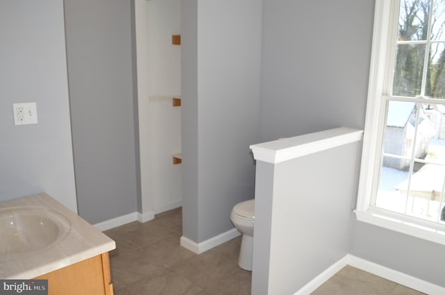 bathroom featuring vanity, tile patterned flooring, plenty of natural light, and toilet