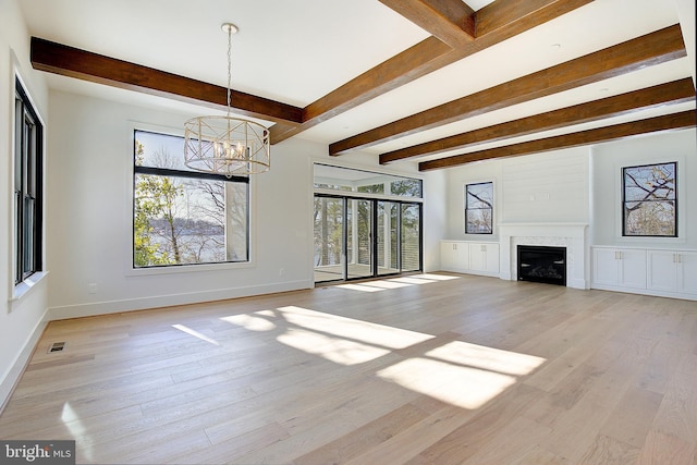 unfurnished living room featuring beam ceiling, light hardwood / wood-style flooring, and a chandelier