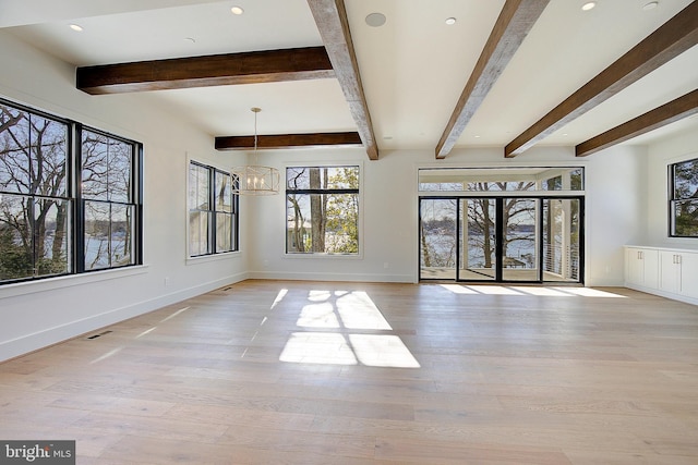 unfurnished living room featuring beamed ceiling, an inviting chandelier, and light hardwood / wood-style flooring