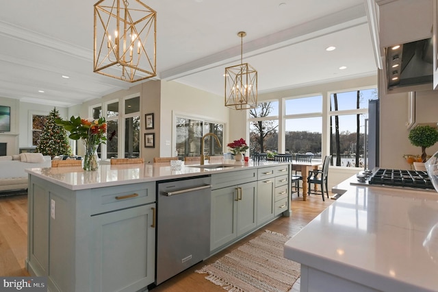 kitchen featuring pendant lighting, beamed ceiling, dishwasher, an island with sink, and sink