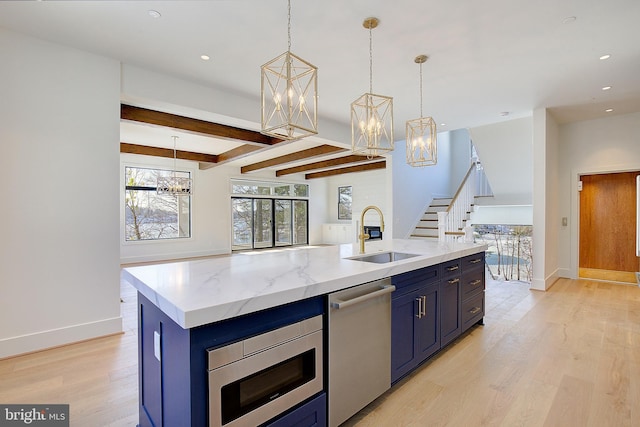 kitchen featuring pendant lighting, beamed ceiling, sink, a kitchen island with sink, and stainless steel appliances