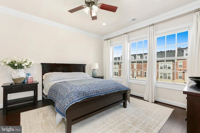 bedroom with crown molding, ceiling fan, and dark hardwood / wood-style flooring