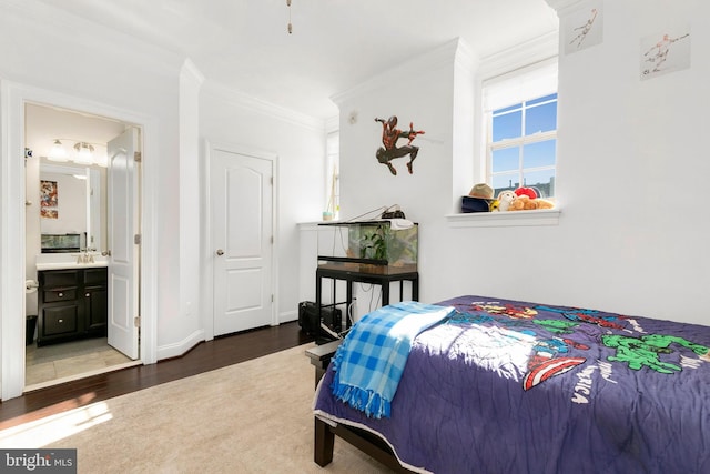 bedroom with crown molding, sink, dark hardwood / wood-style flooring, and ensuite bath