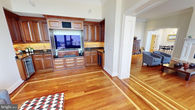 kitchen with tasteful backsplash, hardwood / wood-style flooring, ornamental molding, and stainless steel dishwasher