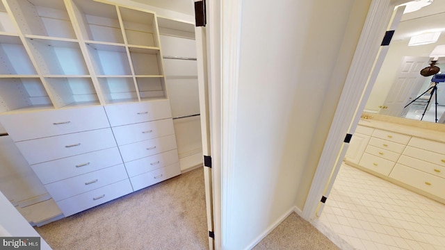 walk in closet featuring light colored carpet