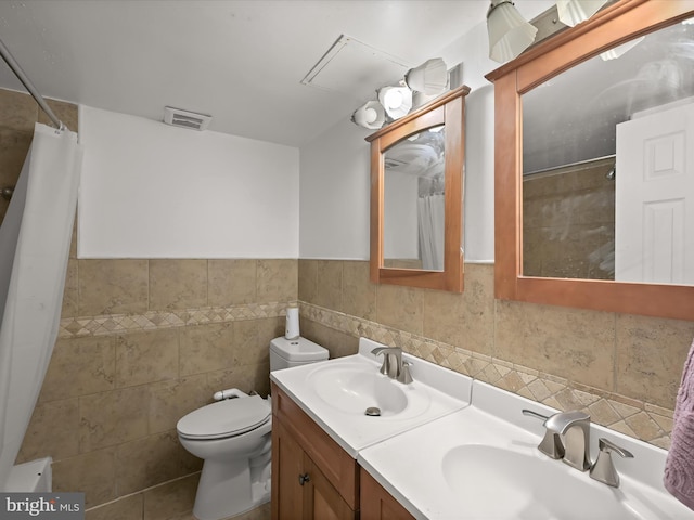 bathroom with vanity, tile walls, toilet, and a shower with shower curtain